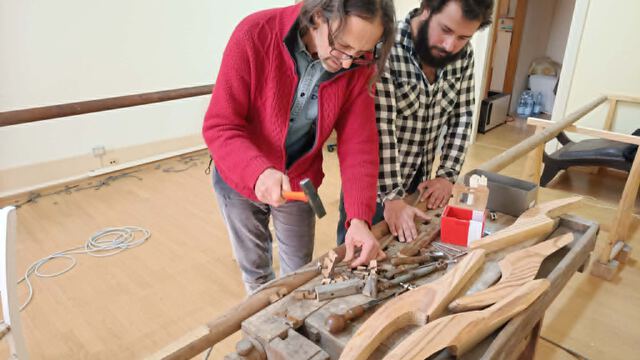 Instructor and student shaping wooden boat components by hand in the Seamanship Academy boat building workshop
