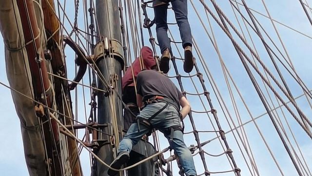 Trainees climbing the rigging of a traditional tall ship during a Sail Training & Boat Handling course